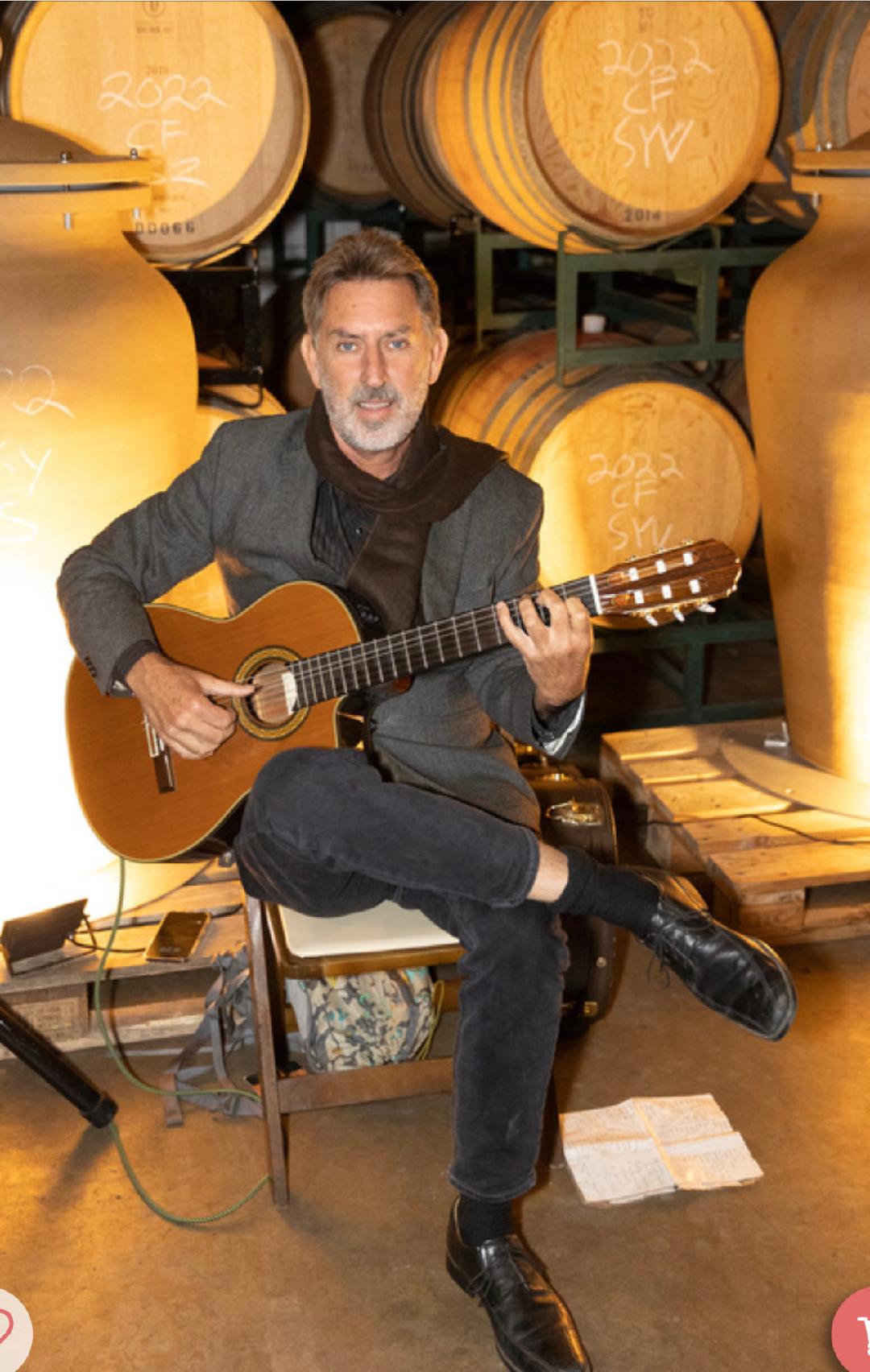 sam-adams-santa-ynez-guitarist-seated-wine-casks Santa Ynez Wedding Musician Sam Adams